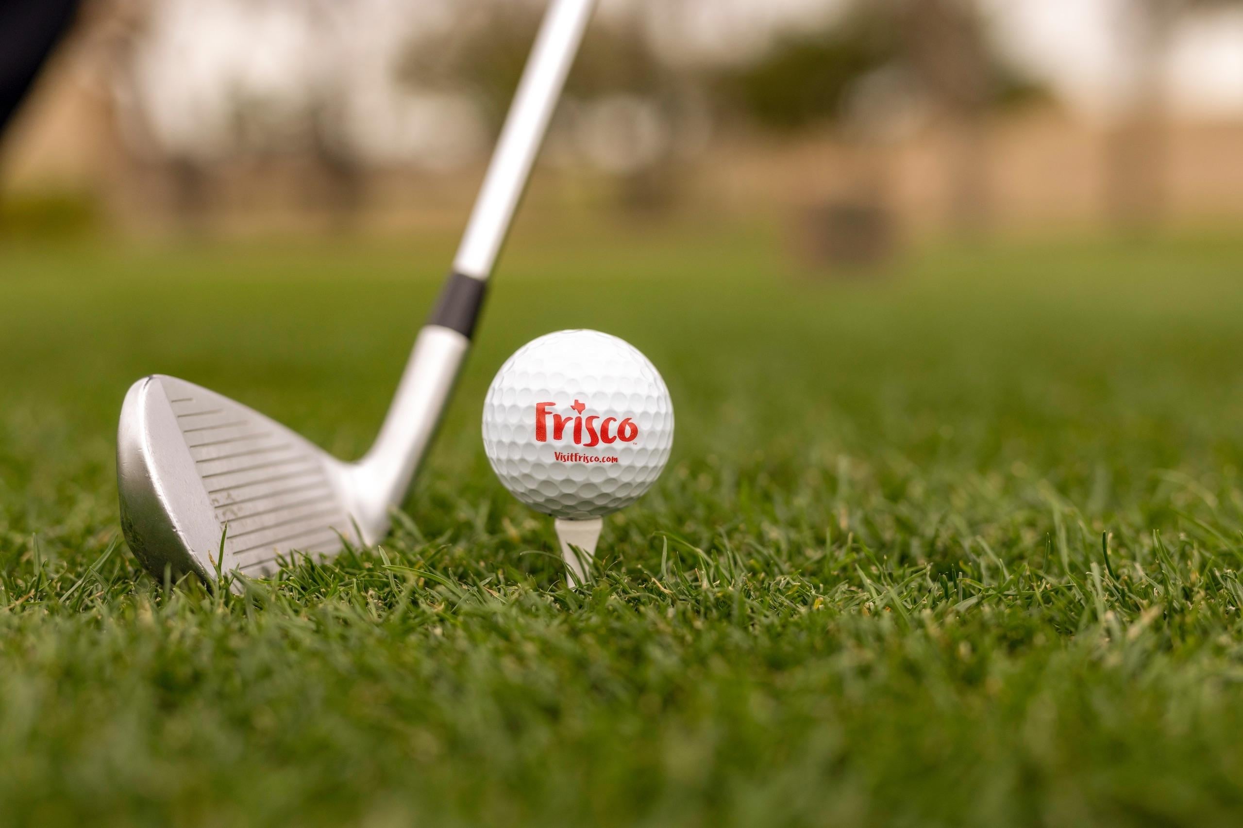 A golfer lining up their club to hit the golf ball off the tee